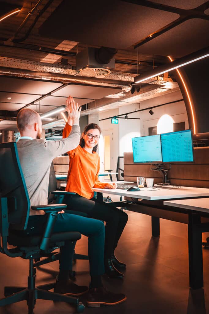 Arianne high fived collega achter beeldscherm